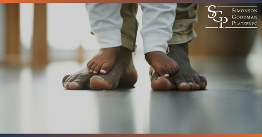 baby feet standing on father feet